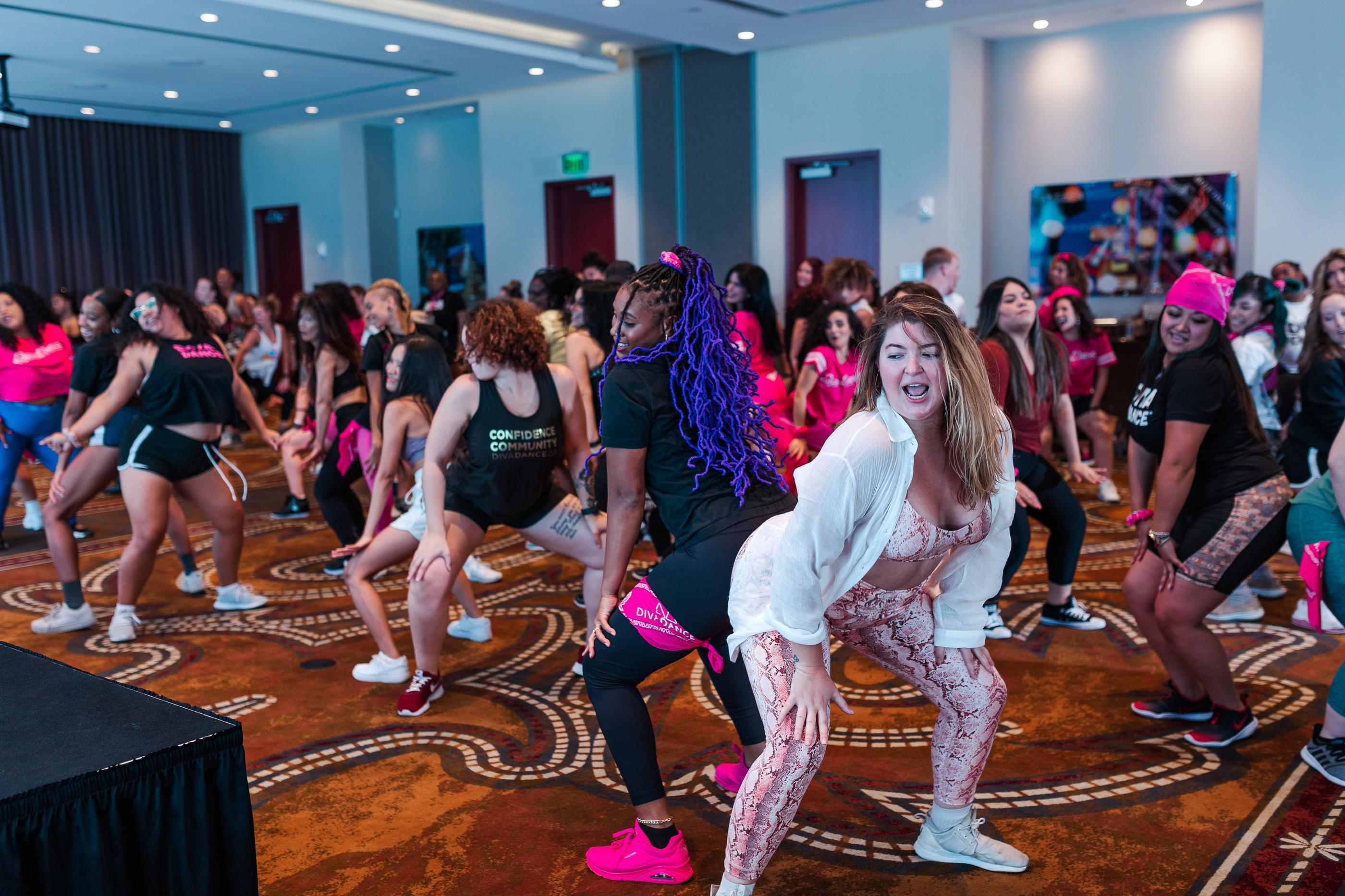 Approximately 30 women learning choreography during a high-energy DivaDance dance fitness class