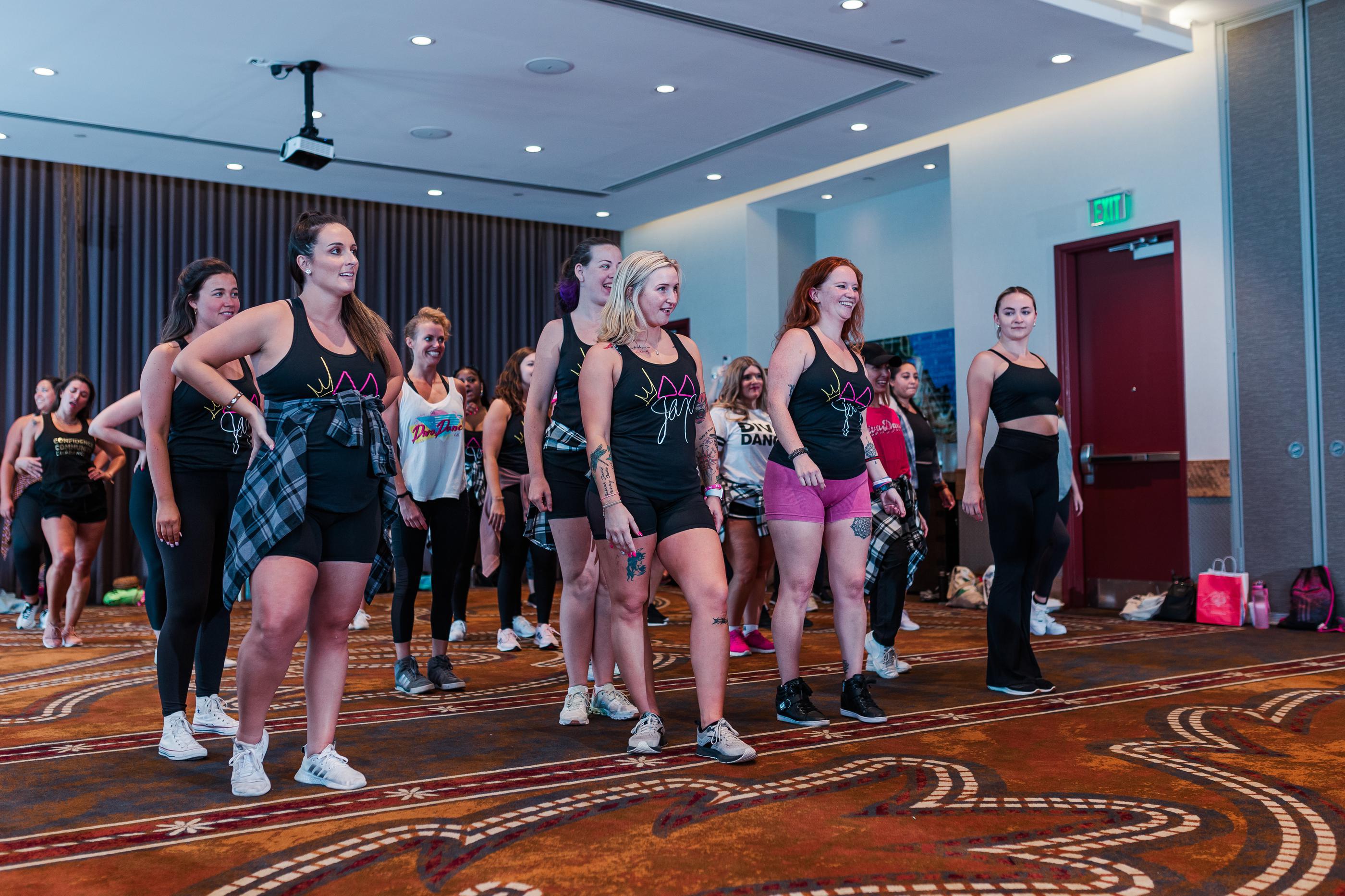 15 women in athletic wear participating in a DivaDance choreography class