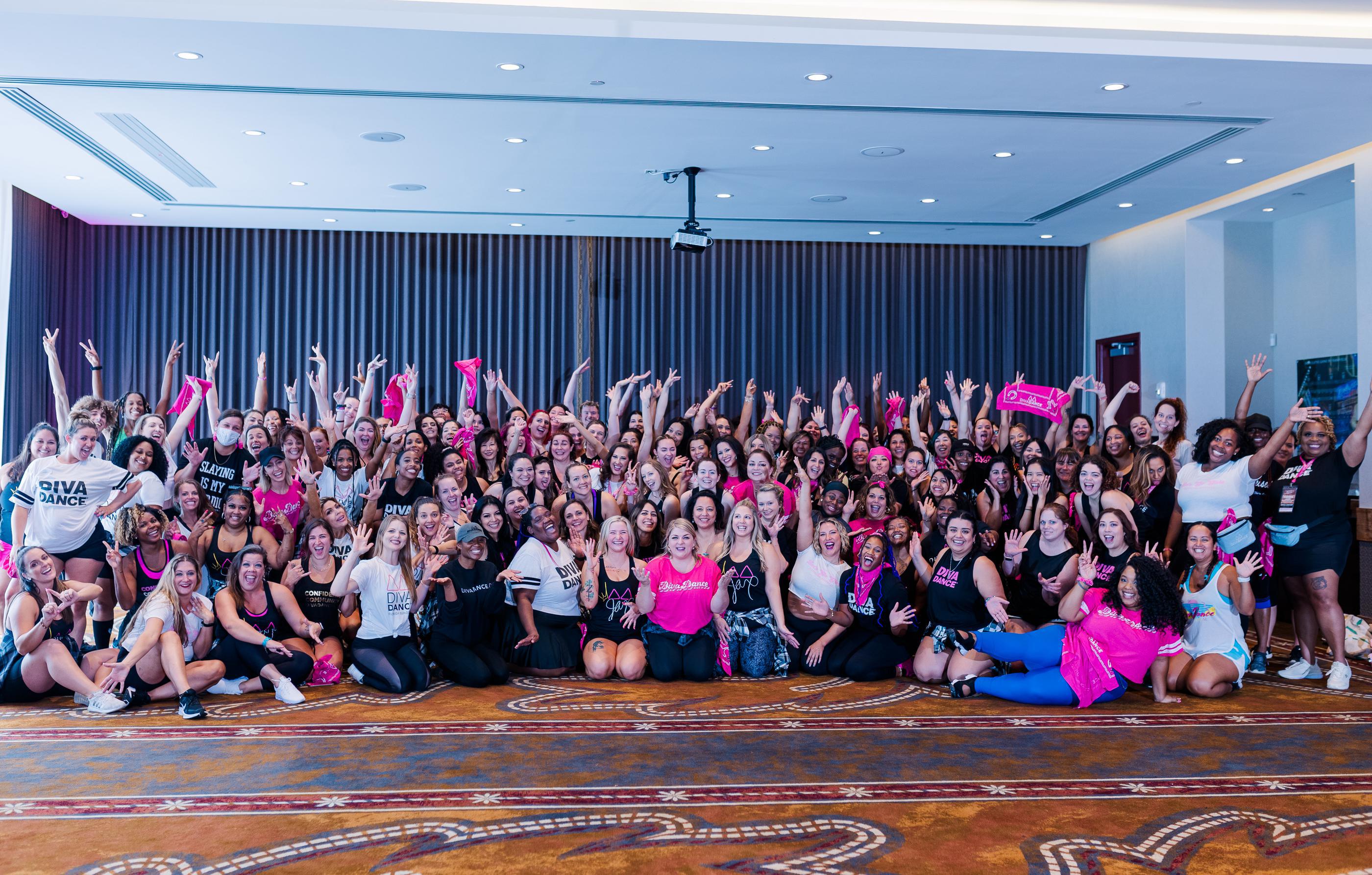 Over 100 women posing for a group photo at a DivaDance dance fitness event